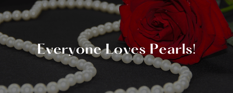 string of beautiful pure white pearls beside a red rose