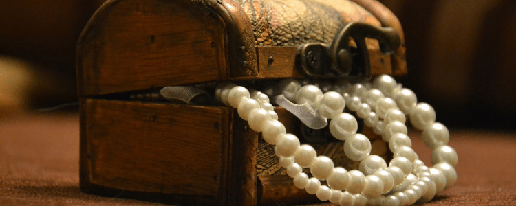 white pearls shown in a beautiful wooden treasure box