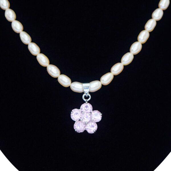 Elegant and cute light pink pearl necklace with flower-shaped pendant studded with pink crystals close up