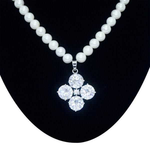 Beautiful white pearls necklace featuring brilliantly shimmering crystal-studded pendant close up
