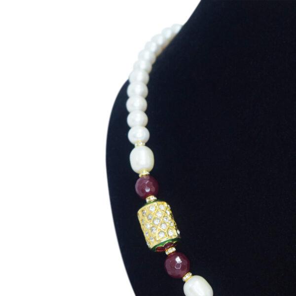 Well-crafted single-layer round white pearl necklace with jadau meenakari dholak bead pendant on the side with SP ruby beads - close up
