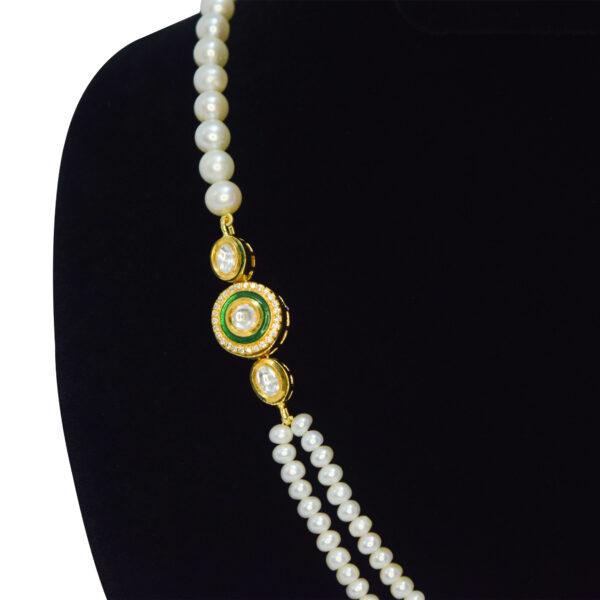 Splendidly crafted two-row white pearl necklace with a kundan brooch on the side - close up