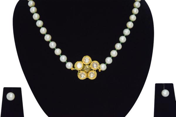 Well crafted single row round white pearl necklace with emerald cz crystals & a floral kundan pendant - close up
