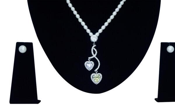 Finely crafted oval white pearl necklace set with a zircon studded pendant with hearts - close up