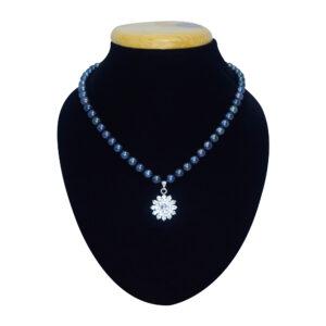 Well crafted indigo blue hued round pearl necklace set with an AD studded floral pendant