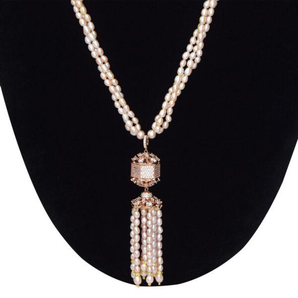 Elegantly crafted triple layer pink pearl necklace set with a rose gold finish zircon studded pendant with tassel pearls - close up