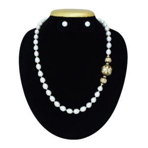 Single-layer oval white pearl necklace interspaced with golden colour beads attached to meenakari dholak beads as a brooch on the side