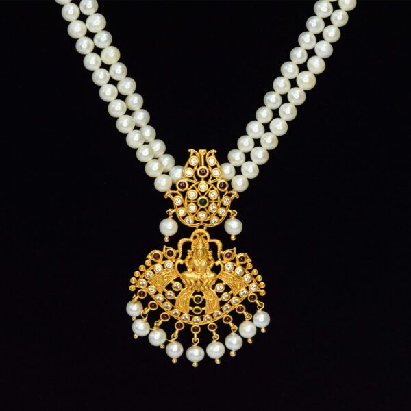 Two-row rich white round pearl long necklace with a traditional matt finish Lakshmi pendant studded with zircons, semi-precious Rubies & Emerald - close up