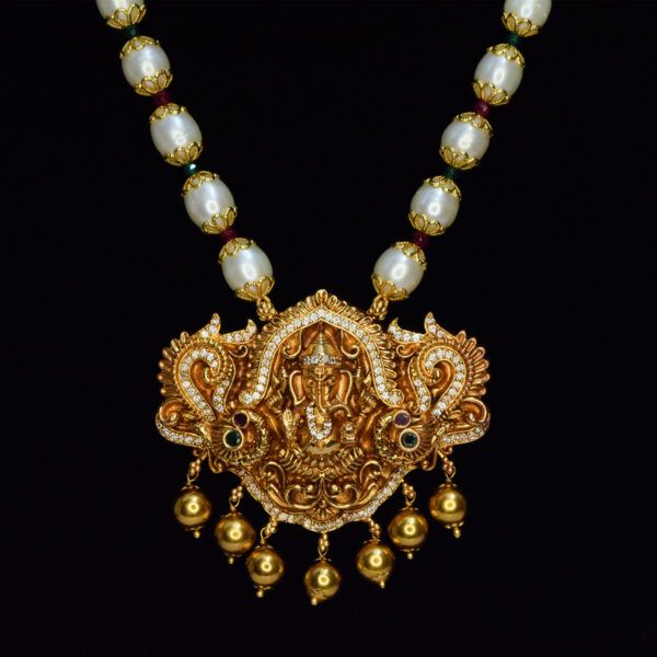 Auspicious golden finish Lord Ganesha pendant strung onto a long & radiant 8.5mm oval white pearls necklace -close up