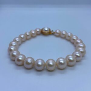 A well-crafted gorgeous bracelet featuring 8.5mm peach round pearls accentuated by a round golden finish clasp.
